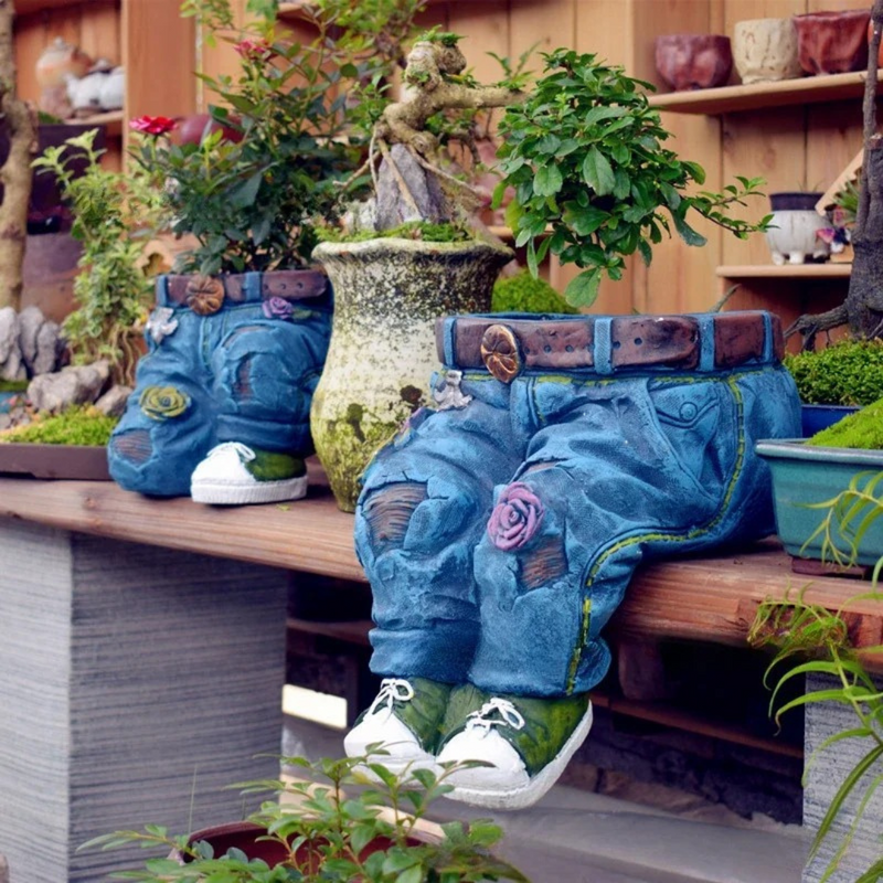 Adicione um toque fofo ao seu jardim com o Vaso Decorativo em Resina com Forma de Jeans. Resistente a intempéries e com design encantador de jeans azul, cinto e tênis, ideal para suas flores e plantas.