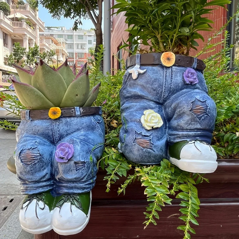 Adicione um toque fofo ao seu jardim com o Vaso Decorativo em Resina com Forma de Jeans. Resistente a intempéries e com design encantador de jeans azul, cinto e tênis, ideal para suas flores e plantas.